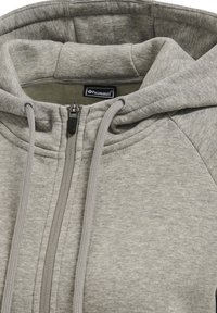 Hellgrauer Kapuzenpullover mit Reißverschluss und Kordeln sowie einem kleinen schwarzen "hummel" Markenlabel innen im Kragen.