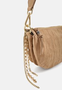 Borsa a sacchetto in camoscio color cuoio con motivo a coccodrillo testurizzato, dettagli in oro, chiusura con zip e catene staccabili.