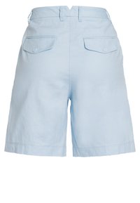 Light blue linen shorts featuring a mid-rise waist, two back pockets with button closures, and a relaxed fit with a hemline above the knee.