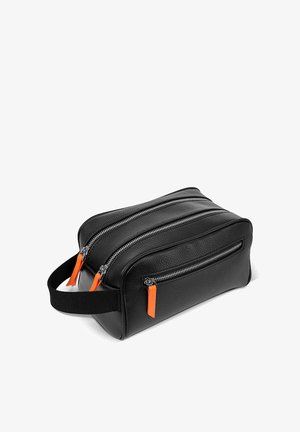 Czarna teksturowana skórzana kosmetyczka z trzema kieszeniami na zamek błyskawiczny oraz pomarańczowymi uchwytami zamków, a także czarnym materiałowym paskiem do przenoszenia.