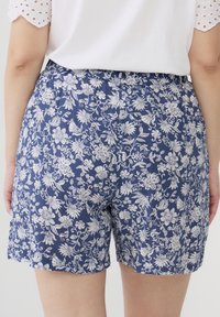 Pantaloni corti con stampa floreale in blu navy con motivi bianchi. Tessuto morbido, vita elastica e taglio dritto. Senza tasche o dettagli hardware.