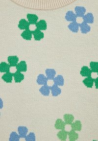 Stickad tröja med en krämfärgad bakgrund och blå och gröna blommönster. Texturen är mjuk och lyfter fram de livfulla stickade blommorna.