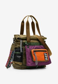 Khaki og lilla multifunktions taske med orange detaljer, der har justerbare stropper og forskellige teksturer, herunder mesh og glat stof.