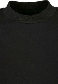 Suéter negro con un cuello redondo acanalado y una textura suave y lisa, con un ajuste ceñido y costuras uniformes en todo su diseño.