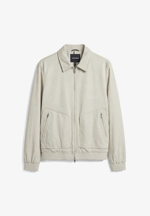 Chaqueta color beige claro con cremallera, cuello, puños y bajo elásticos, dos bolsillos delanteros con cremallera y una etiqueta interior negra.