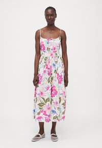 Blumenkleid in Midi-Länge mit Spaghettiträgern, verziert mit rosa, lila und grünen Blumen auf hellem Hintergrund; geraffte Taillendetails.