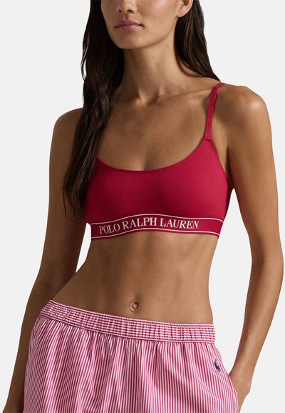 Röd bomulls-bh med tunna band och kontrasterande vit text "POLO RALPH LAUREN". Kombinerad med röda och vita randiga pyjamasshorts.