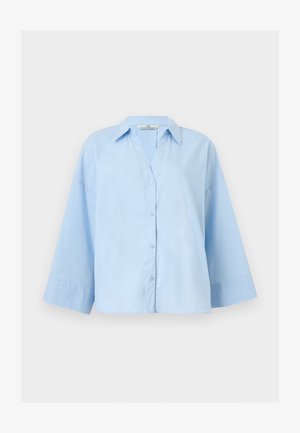 Ανοιχτό μπλε, υπερμεγέθη πουκάμισο με φαρδιά μανίκια τριών τετάρτων και κλασικό γιακά, απλωμένο επίπεδα σε ανοιχτό φόντο.