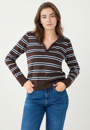 Braun-weiß gestreifter Polopullover mit langen Ärmeln, V-Ausschnitt und gerippten Bündchen, kombiniert mit blauen Jeans aus Denim.