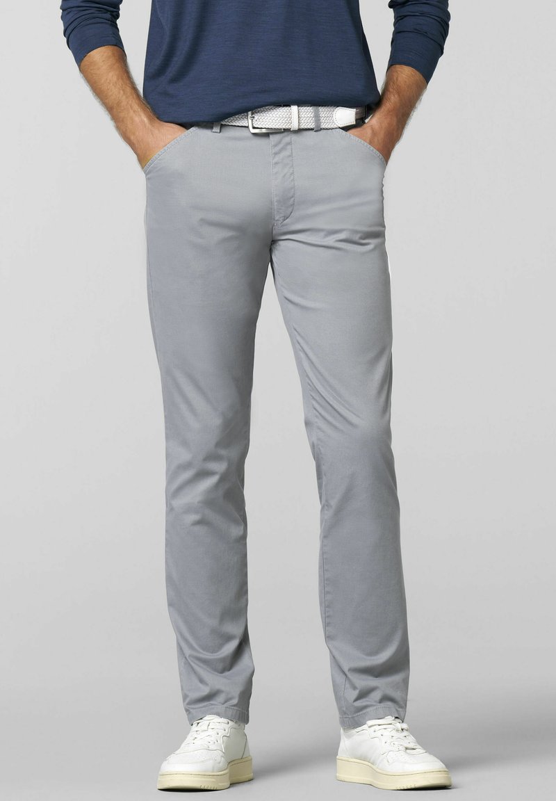 Helle graue Chinos mit schlanker Passform, ausgestattet mit Seitentaschen und einem weißen gewebten Gürtel. Kombiniert mit weißen Sneakers, die einen lässigen Look zeigen.