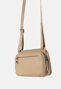 Borsa a tracolla in pelle beige con forma rettangolare, tracolla regolabile, tasca con zip e dettagli di cucitura minimi.