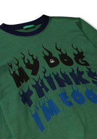 Groen katoen crewneck trui met gedurfde zwart en blauwe vlamvormige tekst. Marineblauwe kraagaccent. Zachte textuur met een casual pasvorm.