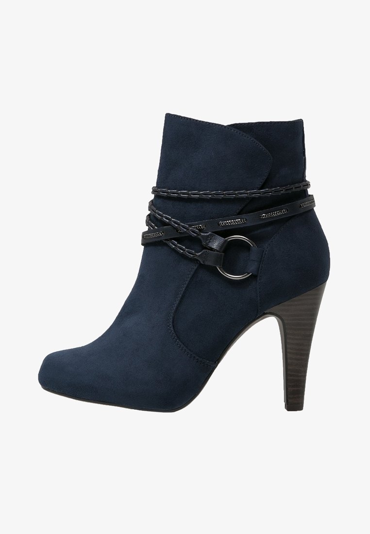 Bottine en daim marine à bout pointu, avec un talon empilé et une sangle noire décorative avec un détail en anneau autour du tige.