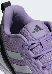 Light purple athletic shoe featuring a textured upper, silver accents, and a padded collar. Laces and a pull tab add functionality.