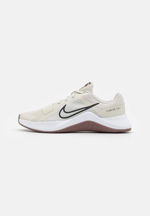 Chaussure de course Nike beige avec logo swoosh noir, semelle intermédiaire blanche et semelle extérieure marron texturée, vue de profil droit sur fond blanc.
