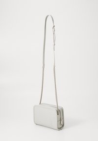 Světlě šedá kožená crossbody taška, obdélníkový tvar, hladká textura, nastavitelný popruh s řetízkov�ými akcenty, zipové uzavření na vrchu.