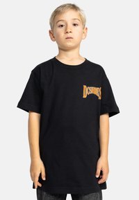 Černé bavlněné tričko s krátkým rukávem. Na levé straně má logo „DC Shoes“ v oranžové barvě. Standardní střih s kulatým výstřihem.