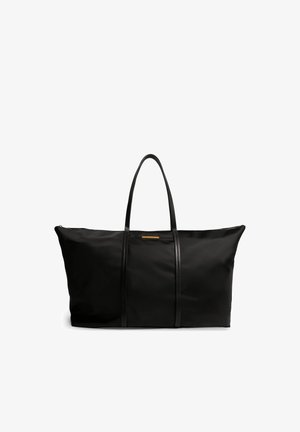 Sac cabas noir au design spacieux, fabriqué en tissu durable, doté de deux longues anses en cuir noir contrastant et d'une fermeture éclair.