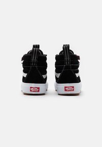 Černé semišové vysoké tenisky s bílou mezipodešví, kontrastním bílým pruhováním po straně a texturovanou gumovou podrážkou s logem na patě.