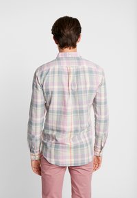 Langärmliges karierter Hemd in Pastellfarben, mit einer Rückenfalte und Knopfmanschetten. Der Stoff hat eine glatte Textur und ein leichtes Gefühl.