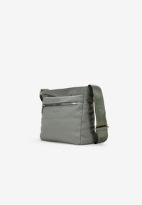 Bolso bandolera gris con un tejido texturizado, que presenta un bolsillo delantero con cremallera, costuras en contraste y una correa verde ajustable. Forma rectangular moderna.