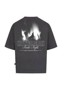 Šedé oversized tričko vyrobené z bavlny, se siluetou černého vlka a textem "CRYSTALPARIS Nordic Nights" na zadní straně.