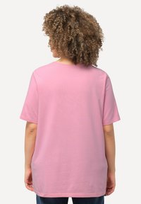 Růžové oversized tričko s krátkým rukávem, kulatým výstřihem, vyrobené z měkké bavlny, s jednoduchým designem bez viditelných vzorů nebo log.