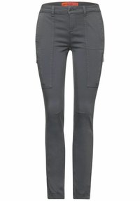 Grå slim-fit byxor med en ficka med dragkedja, dekorativa nitar på sidan och knädetaljer, tillverkade av lätt, flexibelt tyg.