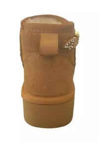 Stivale alla caviglia in suede marrone con suola in gomma tan piatta, dotato di una cinghia decorata con strass e un morbido rivestimento interno.