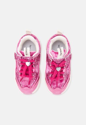Paire de baskets roses pour enfants avec détails scintillants, breloques en forme de cœur sur les lacets, et doublure intérieure blanche vue de dessus.