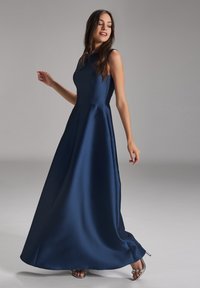 Langes navyblaues Satin-Kleid mit tailliertem Oberteil, weit schwingendem Rock und elegantem nahtlosem Design. Es hat einen Rundhalsausschnitt und eine fließende Silhouette.