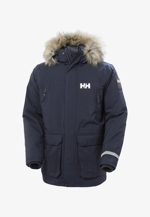 Námořnická modrá parka s kapucí lemovanou umělou kožešinou, několika předními kapsami a reflexními akcenty. Vyrobena z voděodolného materiálu.