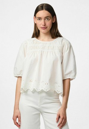 Blusa bianca in cotone con scollo rotondo, maniche a sbuffo e dettagli in occhio di pernice lungo l'orlo. Tessuto morbido; vestibilità ampia e rilassata.