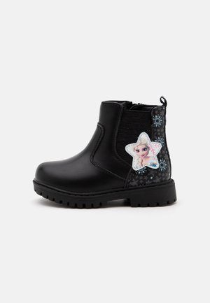 Botte noire pour enfants avec motif flocon de neige et un patch en forme d'étoile mettant en vedette un personnage animé blond sur le côté.