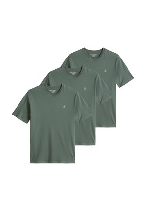 Trois t-shirts verts à manches courtes et col rond superposés, chacun avec un petit logo blanc sur la poitrine gauche.