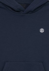 Felpa blu navy realizzata in morbido cotone, con tasca a marsupio e piccolo logo bianco sul petto. Texture liscia e design casual.