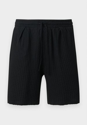 Short noir texturé avec taille élastique et cordon, muni de deux poches latérales et d'une coupe mi-cuisse.