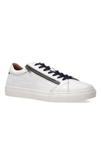 Hvide lædersneakers med en sidelukning, marineblå snørebånd og en struktureret gummisål. Funktionen inkluderer en brun læderdetalje nær lynlåsen.
