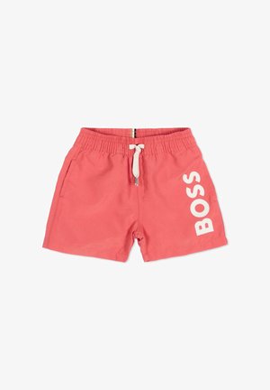 Shorts de bain rose corail avec taille à cordon blanc et grand texte blanc « BOSS » imprimé verticalement sur la jambe droite.