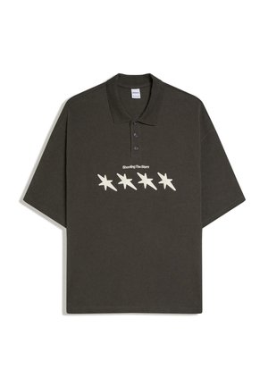 Tmavozelené polo tričko s trojguľovým zapínaním, na ktorom sú štyri krémové hviezdne tvary a na hrudi text "Shooting The Stars".