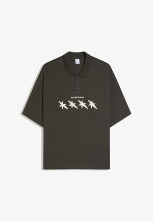 Sötét olívazöld galléros póló, háromgombos sliccsel, négy krém csillaggal és a "Shooting The Stars" felirattal a mellkason.