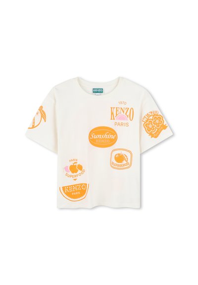 T-shirt en coton blanc avec des designs graphiques orange, incluant des fruits et des noms de marque, avec une coupe ample et un col rond.