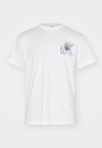 Hvid bomulds t-shirt med et lille illustreret design af en figur med blomster som hoved i blå og gule toner. Klassisk crew neck stil.