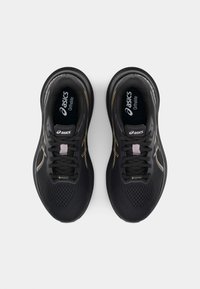 Black athletic shoes with mesh uppers, textured soles, and reflective accents. Features include laces, cushioned insoles, and a waterproof logo.