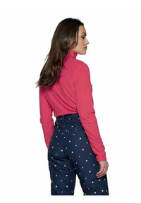 Maglioncino rosa a maniche lunghe con colletto alto abbinato a pantaloni blu navy con motivi di stelle bianche. Tessuto morbido, design aderente e cuciture solide.