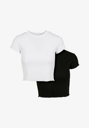 To crop topper: en hvit og en svart. Begge har ribbet tekstur og korte ermer med bølgede kanter. Enkelt design.