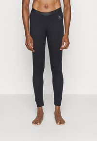 Schwarze Leggings aus dehnbarem Material, mit einem breiten Bund und eng anliegenden Knöcheln. Logo auf dem oberen linken Oberschenkel gedruckt.