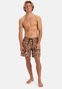 Hnědé plavky s tropickým listovým vzorem v béžové barvě, s elastickým pasem a kordem. Vyrobeno z lehkého, rychleschnoucího materiálu.