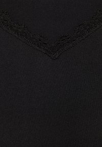 Tela negra con un escote en forma de V adornado con un delicado borde de encaje negro. Textura suave con un acabado ligeramente mate.