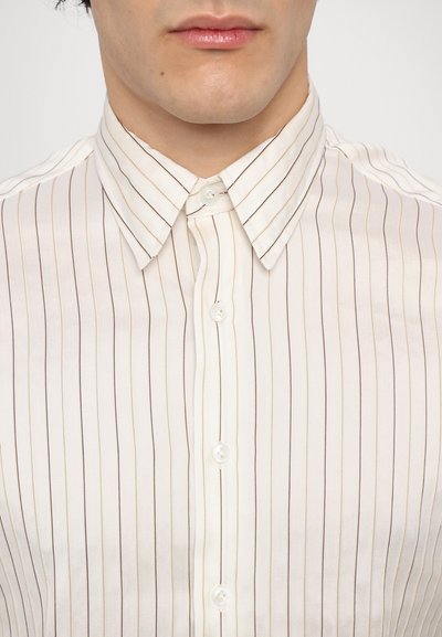 Camisa de botón de rayas crema con finas líneas verticales marrones, con cuello puntiagudo y botones de perla. Textura de tela suave.